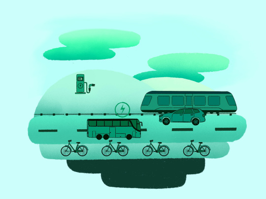 Ein ElektroTriebwagen fährt auf Schienen. Parallel dazu sind ein Bus und ein Auto unterwegs. Auf der FahrradSpur fahren vier Fahrräder. Im Hintergrund steht eine ElektroLadeSäule.